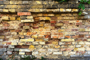 old wall of a crumbling castle. various antique stones make up the wall in the street