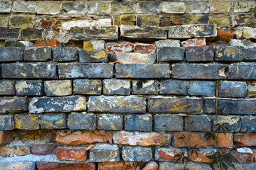 an old street wall made of blue, orange and yellow stones