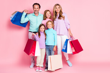 Full size photo of big full family enjoy shopping center dad daddy mom mommy three little kids buy purchase hold bags isolated over pastel pink color background