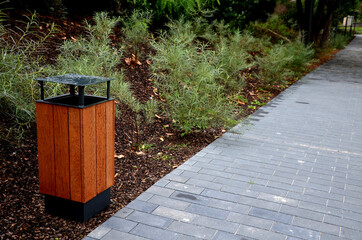 gray concrete park path under the slope overgrown with gray bushes of the species tamarisk...