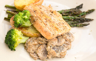 dish of fried river trout fillet with garnish of broccoli, asparagus sprouts and mushroom sauce