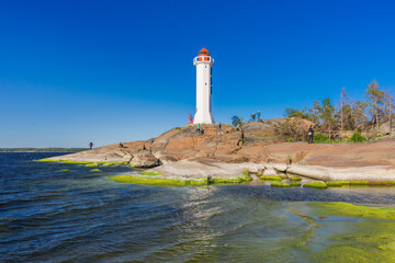 Rocky coast with white lighthouse at sea