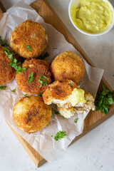 Classic homemade Italian arancini. Fried rice balls with minced meat served with parsley and cheese sauce. Top view.
