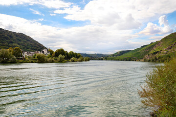 The Moselle river in western Germany near the mouth of the river in Koblenz in the background buildings and wineries, the water flows calmly.