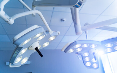 Two surgical lamps in operation room. Blue cast light in clinic. Modern equipment in surgery room. Operating theatre. Closeup.