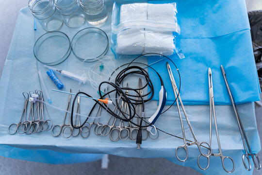 Surgical instruments and tools including scalpels, forceps and tweezers. Arranged surgery tools on a table in operating room.