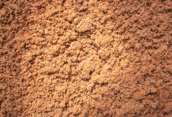 Texture of red soil, close up. Brown cement surface. Rock pattern. Weathered mud, macro. Solid sand wallpaper.