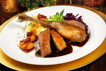 Roasted Christmas Goose on a golden Plate with Christmas Decoration