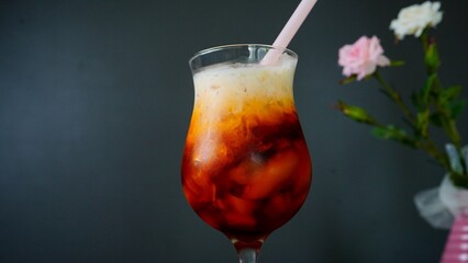 Homemade Thai iced / ice tea on dark moody background, selective focus