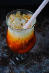 Homemade Thai iced / ice tea on dark moody background, selective focus