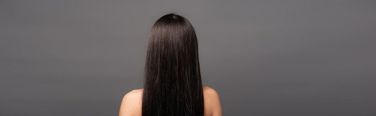 back view of naked brunette long haired woman isolated on black, panoramic shot