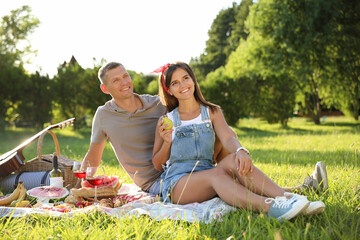 Fototapeta premium Happy couple having picnic in park on sunny day