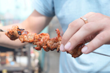 a man holding a skewer with