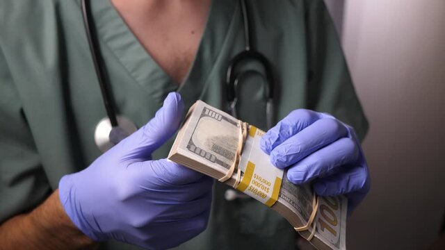 Doctor wearing uniform and a stethoscope counting cash money