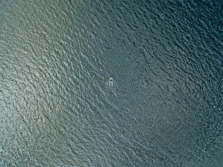 Aerial drone view. Fishing boat on the waves of the river.