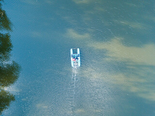 Aerial drone view. Catamaran in a pond in the park.