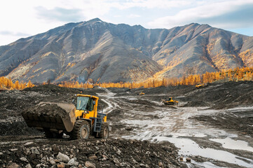 Front-end loader in the mode of transporting mountain soil. Earthworks in mountainous areas.