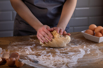 The chef's hands are kneading the dough for dumplings, pasta, bread, or pizza. Cooking dumplings – step by step guide.