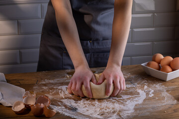 The chef's hands are kneading the dough for dumplings, pasta, bread, or pizza. Cooking dumplings – step by step guide.