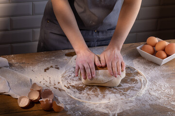 The chef's hands are kneading the dough for dumplings, pasta, bread, or pizza. Cooking dumplings – step by step guide.