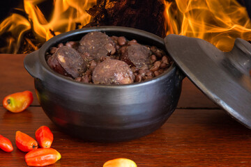 Feijoada. Traditional Brazilian food. Background with fire.