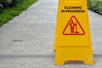 Yellow cleaning warning sign on sidewalks.