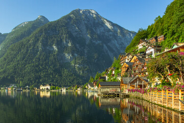Fototapeta premium Classic postcard view of famous Hallstatt lakeside town, Austria. Scenic panoramic view of beautiful town reflecting in Hallstatter See.Beautiful sunny day in summer, Salzkammergut region.Urban scene