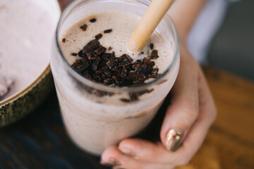 Top view of female holding jar with organic smoothie from fruits and cereals for refreshment and organic nutrition, cropped image of taty sweet beverage for low fat dieting nutrition lifestyle