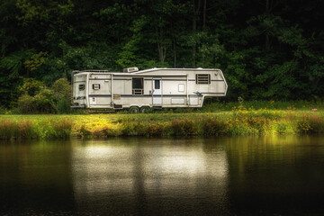 A White 5th wheel camper sits by the pond on a farm in Upstate NY on Labor Day 2020