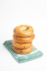 A Stack Of Four Freshly Baked Bagels On A Green Napkin