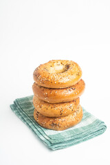 A Stack Of Four Freshly Baked Bagels On A Green Napkin