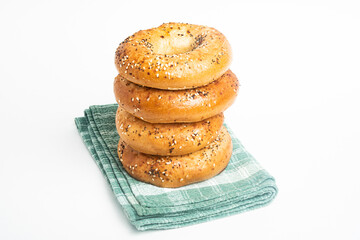 A Stack Of Four Freshly Baked Bagels On A Green Napkin