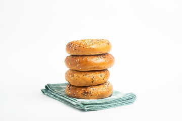 A Stack Of Four Freshly Baked Bagels On A Green Napkin