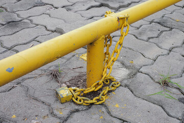 Close up of the padlock and iron chain painted in yellow old condition on the floor,Ideal for use in the design