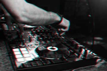 hands on DJ playing music on professional mixer controller in nightclub