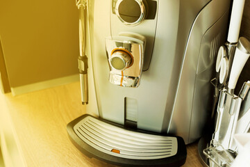 Close up photo of coffee office machine with orange lens flare