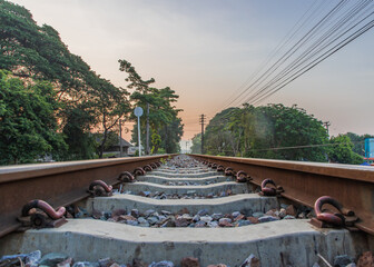 Old railroad train tracks in the countryside against beautiful sky in nature. Transport and shipping landscape concept. Selective focus.