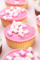 Colorful cupcakes on a pink background.