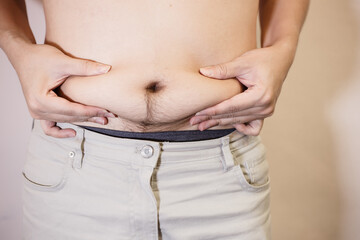 Naklejka premium Fat man, Obese man hand holding excessive belly fat isolated on white background.