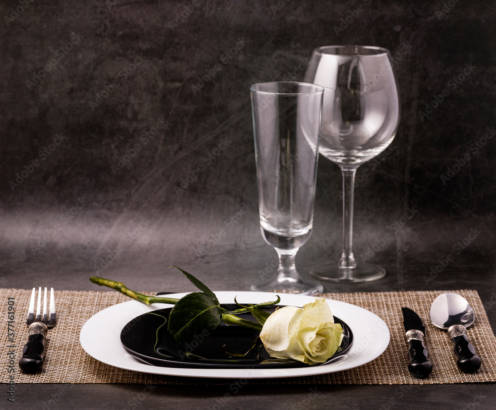 Wall mural white rose flower on a set of dishes. the concept of a romantic dinner.