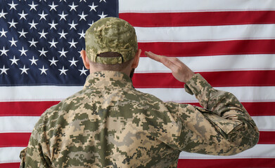Soldier in uniform against United states of America flag, back view