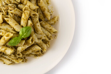 Penne pasta with pesto sauce isolated on white background