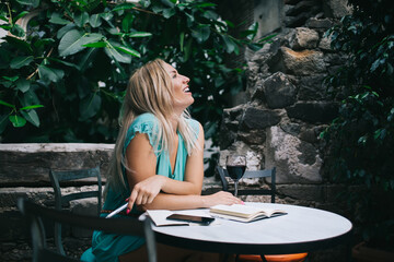 Happy woman enjoying creativity time for perform author's journalistic content sitting in street...