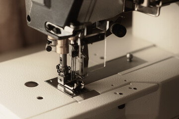 Industrial flat-seam sewing machine. Close-up. Soft focus