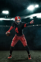 American football player in action, athlete sportsman in red helmet on stadium background. Sport and motivation wallpaper.