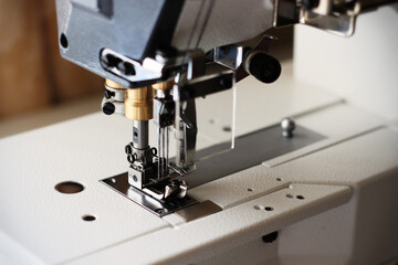 Industrial flat-seam sewing machine. Close-up. Soft focus