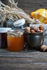 Various jars with homemade canned fruit and vegetable jam, honey and nuts and grains, pumpkin and  chestnuts, 