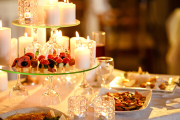 Romantic luxury dinner for lovers indoor. Tasty dishes. New year, valentine day or anniversary. Burning candles on the table