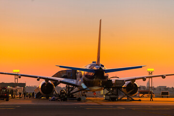 Fototapeta na wymiar Passengers airplane on runway in beautiful sunrise light. Copy space
