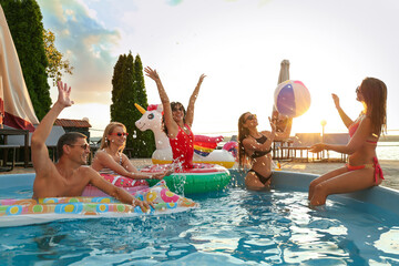 Group of happy people enjoying fun pool party